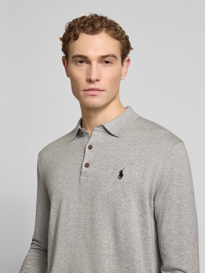 Männermodel trägt Regular Fit Poloshirt aus reiner Baumwolle von Polo Ralph Lauren in Grau, feine Strickoptik, Logo-Detail, Nahaufnahme Oberkörper.