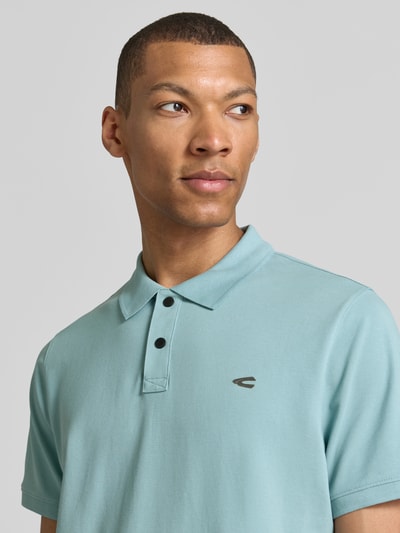 Männermodel trägt Regular Fit Poloshirt in effen design van camel active, mix van katoen en elastaan, logoprint, knoopsluiting, ruglengte bij maat M 70 cm, Nahaufnahme Oberkörper