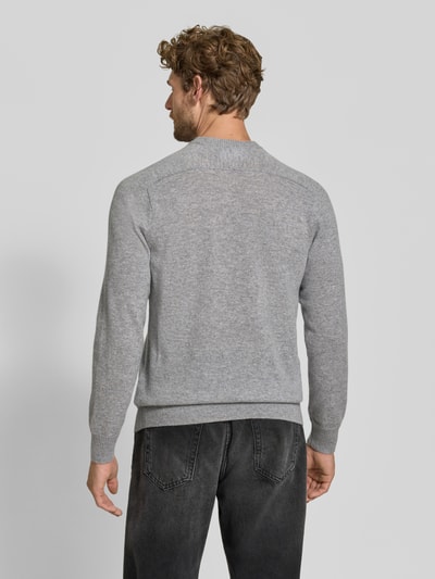 Männermodel trägt Regular Fit Strickpullover aus reinem Kaschmir von FTC Cashmere in Grau, gerippte Abschlüsse, Ganzkörperansicht Rückansicht.