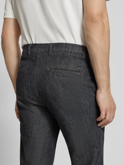 Männermodel trägt Hose in Denim-Optik Modell 'Tino' von BRAX, Baumwoll-Elasthan-Mix, Regular-Fit, Eingrifftaschen, Ganzkörperansicht Rückansicht.