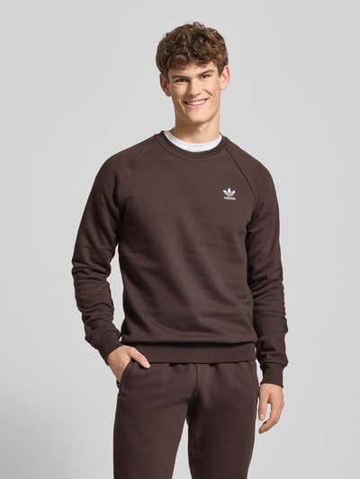 Männermodel trägt Sweatshirt mit Label-Stitching von adidas Originals aus Baumwoll-Elasthan-Mix, lockerer Schnitt, Rundhalsausschnitt, Ganzkörperansicht von vorne.