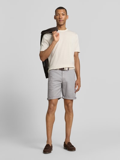 Männermodel trägt Bermudas mit Gürtel und Eingrifftaschen von MCNEAL aus Baumwoll-Mix in Hellgrau, Straight Fit, Ganzkörperansicht von vorne.