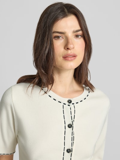 Kobiece model prezentuje Regular Fit Cardigan aus Viskose-Mix od More & More, okrągły dekolt, listwa guzikowa, nakładane kieszenie, rękaw o dł. 1/2, imitacja dzianiny, długość tyłu 56 cm, długość rękawów 32 cm, mieszanka wiskozy; zbliżenie na górę ciała.