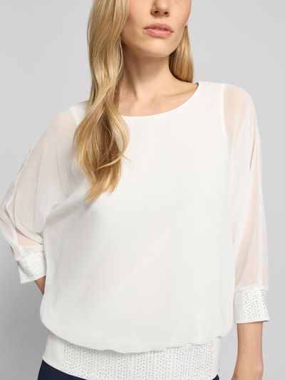 Kobiece modelka nosi Blusenshirt mit Ziersteinbesatz od Vera Mont, krój regular fit, okrągły dekolt, rękaw o dł. 3/4, długość tyłu 59 cm w rozmiarze 36, widok na górną część ciała z przodu.
