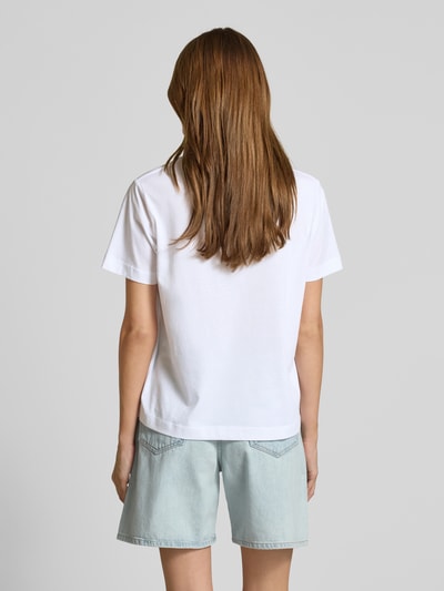 Frauenmodel trägt T-Shirt mit Motiv-Print Modell 'CAMINO' von Samsøe Samsøe in Weiß, reine Baumwolle, Regular Fit, Ganzkörperansicht Rückansicht.