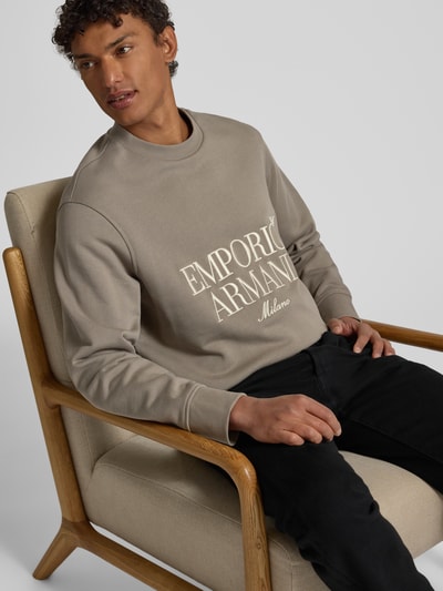 Männermodel trägt Sweatshirt mit Label-Stitching von Emporio Armani in Beige, reine Baumwolle, lockerer Schnitt, Nahaufnahme Oberkörper.