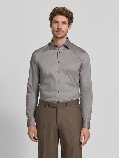 Männermodel trägt Super Slim Fit Businesshemd aus Baumwoll-Mix von OLYMP No. Six in Grau, glatte Textur, Ganzkörperansicht von vorne.