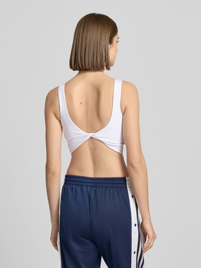 Vrouwenmodel draagt 'BH mit Label-Print' van adidas Sportswear, wit, aansluitende pasvorm, stretchmateriaal, labelprint, rugaanzicht.