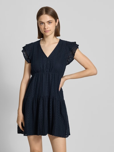 Kobiecy model nosi sukienkę koszulową z mieszanki bawełny Tailliertes Blusenkleid aus Baumwoll-Mix Modell 'HELENA' od Only, efekt: jednolity kolor, krój: taliowany, długość mini, bez kołnierza, hafty, halka pod sukienkę, dekolt w serek, krótkie rękawy, ciemnogranatowa, tekstura ażurowa, widoczne detale na materiale. Ganzkörperansicht z przodu.