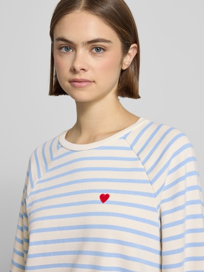 Frauenmodel trägt Oversized Sweatshirt aus Baumwoll-Mix Modell 'GRETA' von Pieces mit Two-Tone-Optik, gestreift, Label-Stitching-Applikation, Nahaufnahme Oberkörper.
