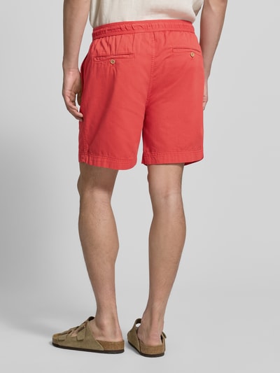 Männermodel trägt Regular Fit Shorts mit elastischem Bund Modell 'SUNFADED' von Gant aus Reine Baumwolle in Rot, Ganzkörperansicht Rückansicht. Herren Shorts, Tunnelzug, Bundweite bei Größe M 43 cm, Innenbeinlänge 15 cm.