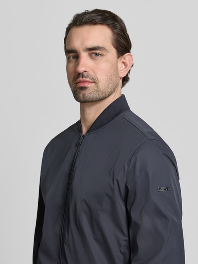 Männermodel trägt Regular Fit Jacke mit Stehkragen Modell 'Rapid' von CINQUE in Dunkelblau, glatte Textur, Nahaufnahme Oberkörper. Rückenlänge, Schulterbreite, Brustweite und Ärmellänge gemäß Größe M.