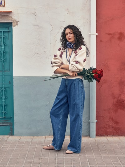 Kobiece modelka nosi Loose Fit Jeans mit Bio-Baumwoll-Anteil od Jake*s Casual, mieszanka bawełny i bawełny ekologicznej, szerokość w pasie 41 cm, długość wewnętrzna nogawki 78 cm, krój loose fit, zapięcie na guzik i zamek błyskawiczny, wpuszczane i tylne kieszenie, kontrafałdy, stylizacje casualowe, niebieski denim, widok całej sylwetki z przodu.