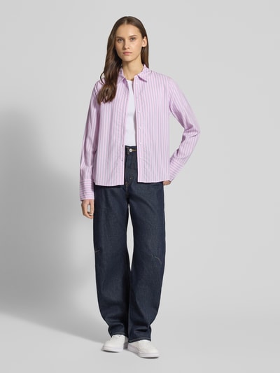 Vrouwenmodel draagt Regular Fit Hemdbluse aus reiner Viskose Modell 'BERIT' van Only met paars gestreept all-over patroon, lange mouw, afgeronde zoom, klassiek overhemdkraag, lichte knoopsluiting, zachte stoftextuur, helemaal van voren gefotografeerd.