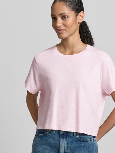 Frauenmodel trägt T-Shirt mit geripptem Rundhalsausschnitt von American Vintage in zartem Rosa, lockerer Schnitt, Nahaufnahme Oberkörper.