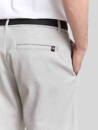 Männermodel trägt Regular Fit Chinoshorts aus Baumwoll-Mix von Tom Tailor Denim in Bi-Color Optik mit Gesäßtasche, Detailaufnahme Rückansicht.