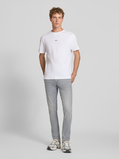 Männermodel trägt Slim Fit Jeans aus Baumwoll-Mix Modell 'Glenn' von JACK & JONES, hellgrau, 5-Pocket-Design, Ganzkörperansicht von vorne. Elastischer Baumwoll-Mix, Knopf- und Reißverschluss, Bundweite 41 cm, Innenbeinlänge 78 cm.