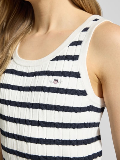 Frauenmodel trägt Stricktop in Ripp-Optik mit Label-Stitching von Gant, weiß mit dunkelblauen Streifen, Baumwoll-Mix, Nahaufnahme Oberkörper.