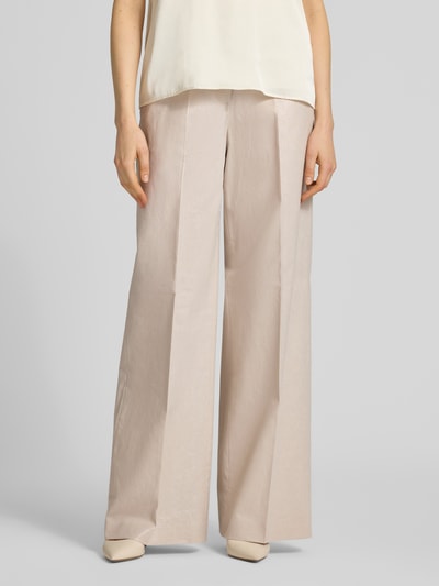 Vrouwenmodel draagt Leinenhose met Bügelfalte und Eingrifftaschen van Christian Berg Cocktail in lichtbeige, loose fit, linnen-mix met katoen, Franse steekzakken, haak- en ritssluiting, bandwijdte 39 cm, binnenbeenlengte 82 cm, detailopname onderlichaam, voorkant.