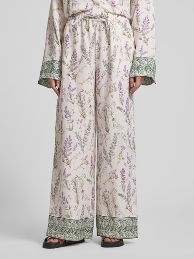 Frauenmodel trägt Wide Leg Leinenhose mit Lavendelprint von Christian Berg Woman, florales Muster, elastischer Bund, Nahaufnahme Unterkörper.