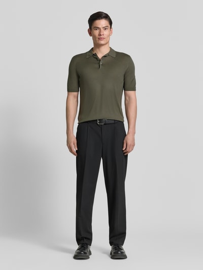 Männermodel trägt Slim Fit Poloshirt aus reiner Seide von GRAN SASSO in Oliv mit Polokragen, semitransparent, kurzärmelig, Ganzkörperansicht von vorne.