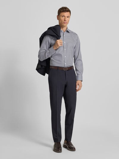 Männermodel trägt Regular Fit Businesshemd aus reiner Baumwolle Modell 'JOE' von BOSS mit Optik: Allover-Muster, gestreift, Ganzkörperansicht von vorne.