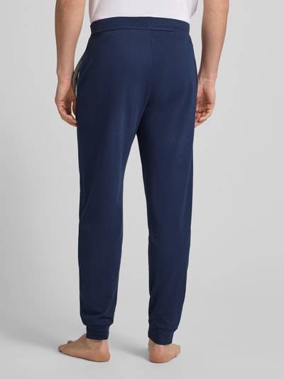 Männermodel trägt dunkelblaue Sweatpants mit elastischem Bund von Christian Berg Men, Baumwolle, gerade Passform, Ganzkörperansicht Rückansicht.