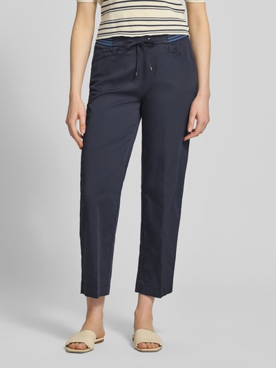Frauenmodel trägt Wide Fit Stoffhose in 7/8-Länge Modell 'Sue' von TONI, dunkelblau, Baumwoll-Mix, Bügelfalten, Tunnelzug, Eingrifftaschen, Ganzkörperansicht von vorne.