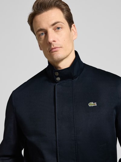 Männermodel trägt Regular Fit Bomberjacke mit Baumwoll-Anteil Modell 'HARRINGTON' von Lacoste, Optik: Unifarben, Nahaufnahme Oberkörper.