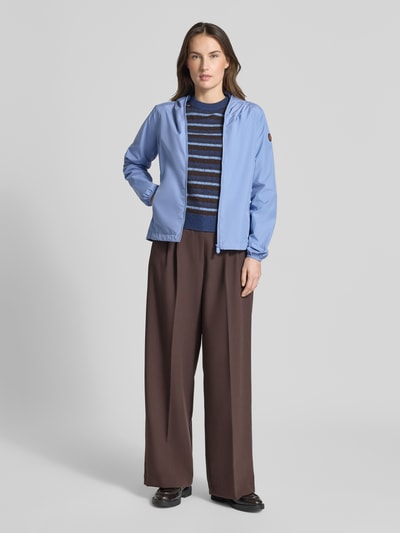 Modelka kobieta nosi Regular Fit Jacke mit Zweiwegereißverschluss Modell 'Stella' od SAVE THE DUCK, jasnoniebieski kolor, gładka tekstura, krój regular fit, dwukierunkowy zamek, boczne kieszenie na zamek, długość tyłu w rozmiarze S: 60 cm, szerokość ramion w rozmiarze S: 42 cm, szerokość klatki piersiowej w rozmiarze S: 52 cm, długość rękawa w rozmiarze S: 64 cm, widok całej sylwetki od frontu.