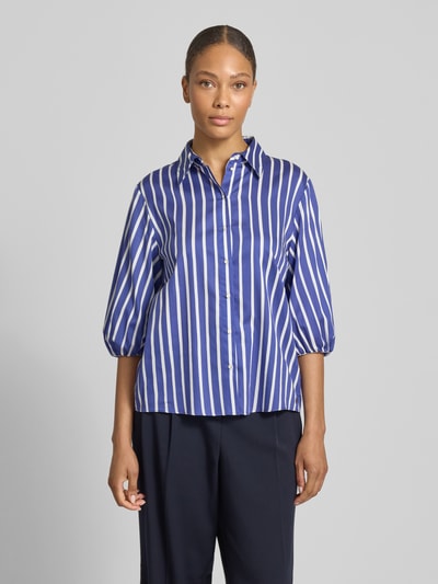 Frauenmodel trägt Regular Fit Bluse mit 3/4-Arm von Marc Cain aus Reine Baumwolle im Allover-Look mit Hemdblusenkragen und Knopfleiste, Ganzkörperansicht von vorne.