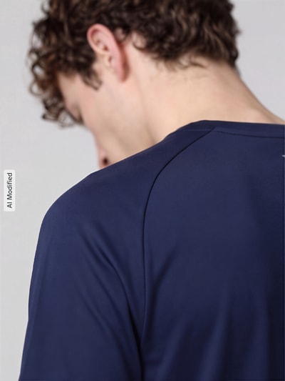Männermodel trägt Regular Fit T-Shirt mit reflektierenden Elementen von Nike, dunkelblau, glatte Textur, Nahaufnahme Rücken, KI-modifiziertes Bild. Herren Sport-T-Shirt von Nike Training.