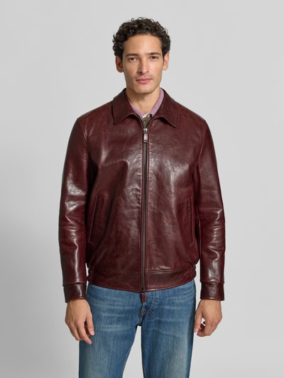 Männermodel trägt Regular Fit Jacke in Leder-Optik mit Umlegekragen von Emporio Armani, dunkelrot glänzend, glatte Struktur, Ganzkörperansicht von vorne.