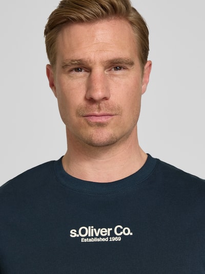 Männermodel trägt Regular Fit T-Shirt aus reiner Baumwolle von s.Oliver RED LABEL, unifarben, kurzarm, Label-Schriftzug, Nahaufnahme Oberkörper
