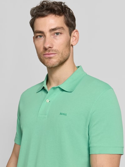 Männermodel trägt Regular Fit Poloshirt aus reiner Baumwolle Modell 'PALLAS' von BOSS, Optik: Unifarben, Nahaufnahme Oberkörper.