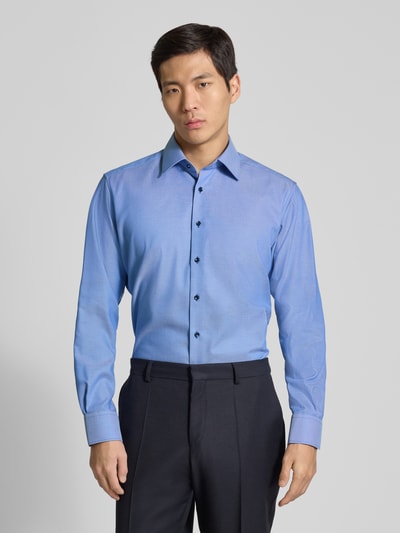 Männermodel trägt Regular Fit Business-Hemd mit Kentkragen von ETERNA in Blau, reine Baumwolle, langärmelig, Ganzkörperansicht von vorne.