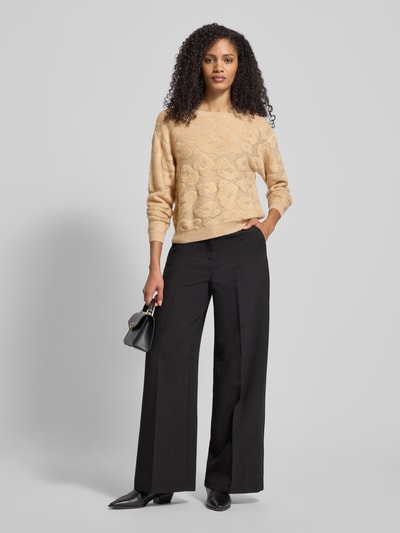 Frauenmodel trägt Sweter z dzianiny z mieszanka materiałów z domieszką wełny z alpaki, krój regular fit, wzór na całej powierzchni, okrągły dekolt, Luisa Cerano, beżowy i czarny, długość tyłu 50 cm, długość rękawów 55 cm, Ganzkörperansicht von vorne.