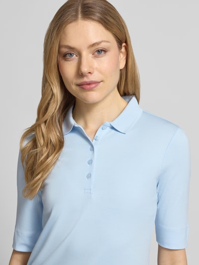 Frauenmodel trägt Slim Fit Poloshirt mit Knopfleiste und 1/2-Arm von Christian Berg Woman aus Reine Baumwolle, Nahaufnahme Oberkörper.