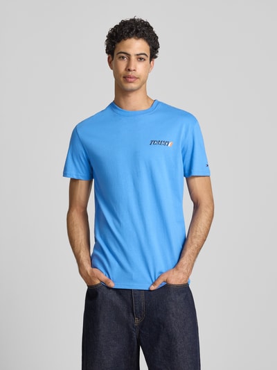 Männermodel trägt Regular Fit T-Shirt aus reiner Baumwolle von Tommy Jeans in Optik: Unifarben mit Label-Print, Rundhals, Kurzarm, Jersey, Ganzkörperansicht von vorne.