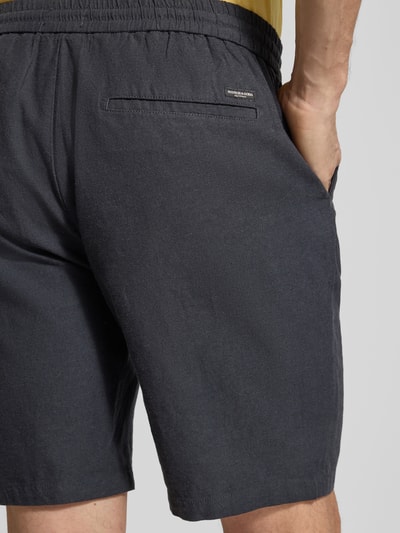 Männermodel trägt Shorts aus Baumwoll-Leinen-Mix Modell 'FAVE' von Scotch & Soda in Dunkelgrau, elastischer Bund, Detailaufnahme Rückansicht. Regular Fit, Bundweite 42 cm, Innenbeinlänge 21 cm (Größe 32).