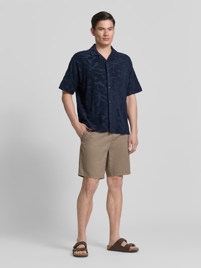 Männermodel trägt Regular Fit Freizeithemd aus Baumwoll-Mix Modell 'WE_FLOWER' von BOSS Orange, Optik: Unifarben, Strukturiert, Strukturmuster, Label-Stitching, Vario-Kragen, durchgehende Knopfleiste, Ärmelform: Kurzarm, Materialverarbeitung: Frottee, Material: Baumwolle-Mix, Ganzkörperansicht von vorne