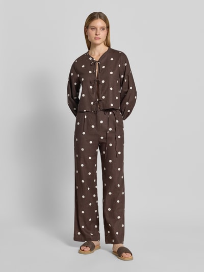 Frauenmodel trägt Stoffhose mit Schleifen-Detail von Jake*s Casual in Braun mit weißen Punkten, Lockerer-Schnitt, Ganzkörperansicht von vorne. Bundweite bei Größe 36: 40 cm, Innenbeinlänge: 83 cm.