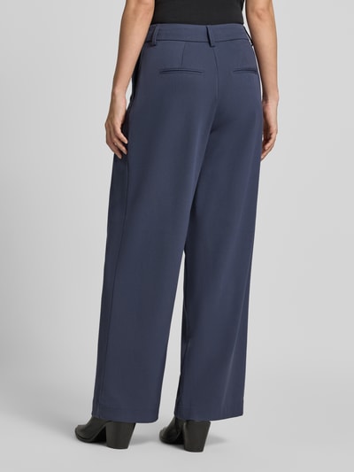 Frauenmodel trägt High Waist Bundfaltenhose mit Bügelfalten Modell 'Henrika' von MSCH COPENHAGEN in Dunkelblau, Webware-Viskosemix, unifarben, Bundfalte und Gürtelschlaufen, Ganzkörperansicht Rückansicht.