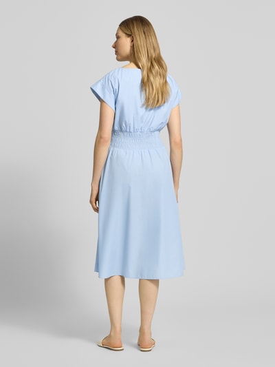 Modelka nosi knielanges Kleid mit Rundhalsausschnitt von Christian Berg Woman Selection, mieszanka bawełny, taliowany fason, długość do kolan, krótkie rękawy, tasiemka w talii, długość tyłu w rozmiarze 36: 110 cm, szerokość klatki piersiowej w rozmiarze 36: 34 cm, jasnoniebieski kolor, gładka tekstura, pełny widok z tyłu