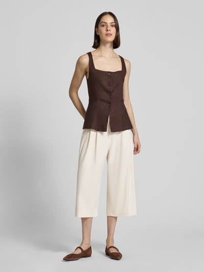 Kobiece model prezentuje kuloty z wpuszczanymi kieszeniami francuskimi model 'TAILOR' od Copenhagen Muse, mieszanka materiałów z dodatkiem wiskozy, krój wide leg fit, zapięcie na haftkę i zamek błyskawiczny, zaszewki, szerokość w rozmiarze S: 39 cm, długość wewnętrzna nogawki w rozmiarze S: 50 cm, kolor kremowy, widok całej sylwetki z przodu.