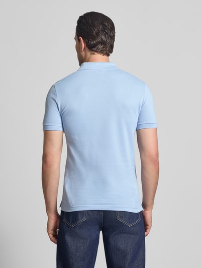 Männermodel trägt Slim Fit Poloshirt aus reiner Baumwolle von Lacoste, Optik: Unifarben, Piqué, Ganzkörperansicht Rückansicht.