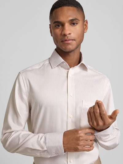 Männermodel trägt Regular Fit Businesshemd aus reiner Baumwolle mit Kentkragen von OLYMP, beige-weiß gestreift, Nahaufnahme Oberkörper.