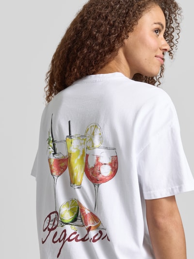 Frauenmodel trägt Oversized T-Shirt mit Label-Print von Pegador aus Reiner Baumwolle mit Rundhalsausschnitt, Rückenlänge 61 cm, Ganzkörperansicht Rückansicht.