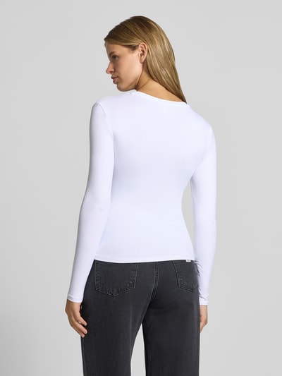 Vrouwenmodel draagt wit shirt met lange mouwen en ronde hals, Slim Fit Langarmshirt met Rundhals-Ausschnitt model 'LULA' van PIECES, Dames, volledig lichaamsaanzicht achteraan.