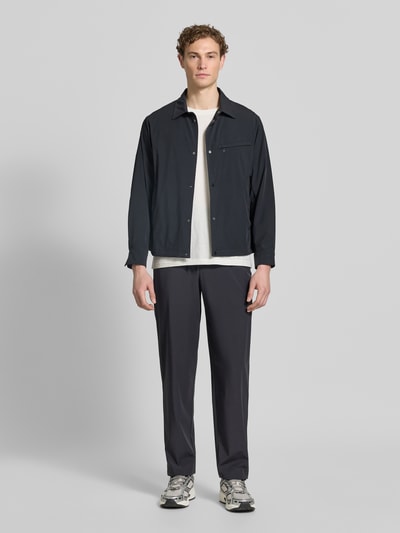 Męski model nosi Hose mit elastischem Bund und Gesäßtaschen von ARMANI EXCHANGE, mieszanka materiałów z dodatkiem streczu, krój relaxed fit, elastyczny pas, kieszenie z tyłu, szerokość w rozmiarze 32: 40 cm, długość wewnętrzna nogawki w rozmiarze 32: 79 cm, kolor ciemny, gładka faktura, widok całej sylwetki z przodu.